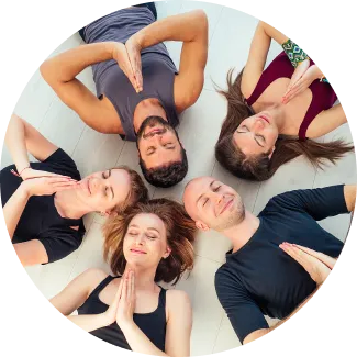 A group in prayer pose, reflecting the focus, peace, and clarity gained through Sri Sri Yoga Level 2